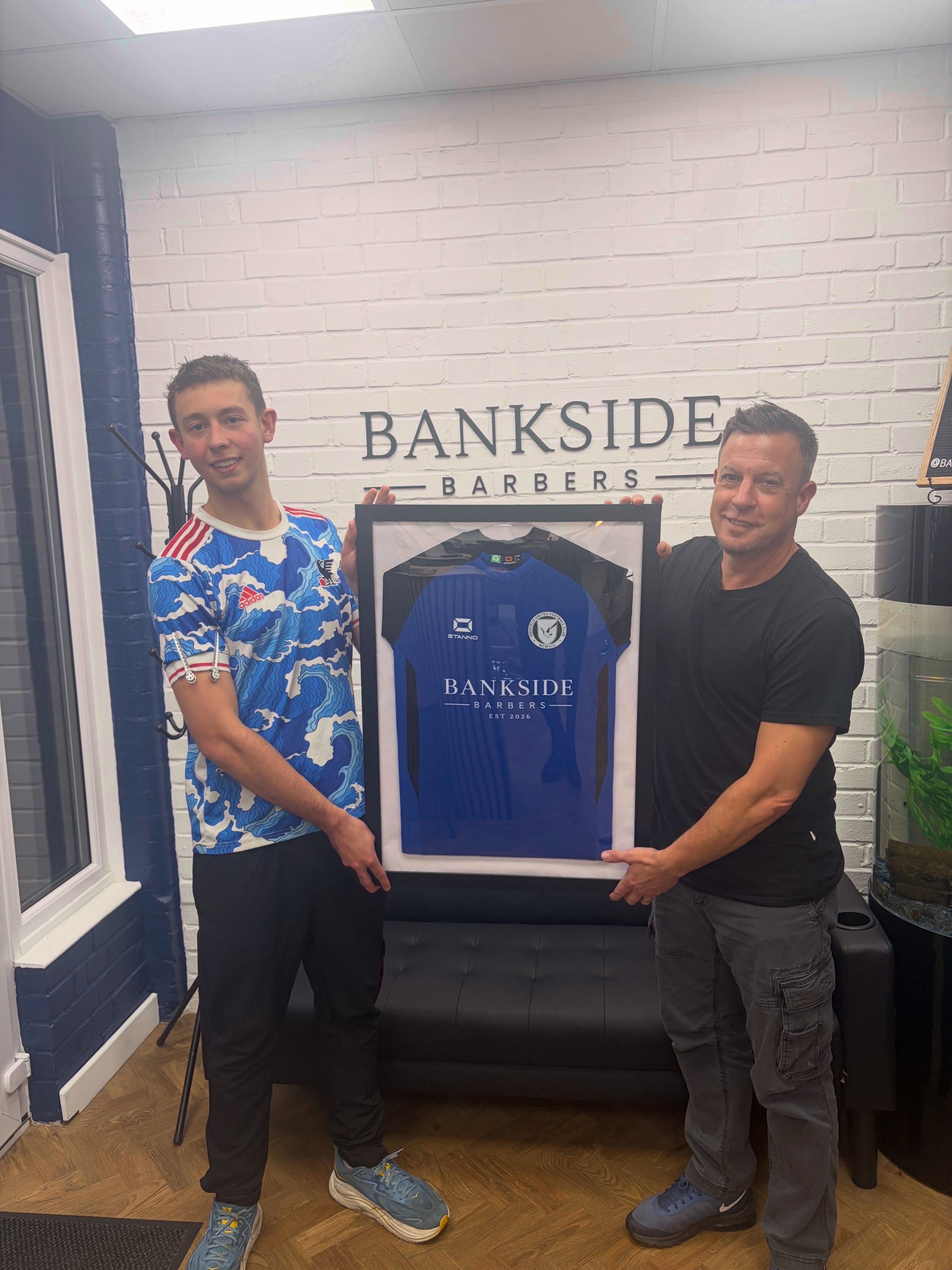Zach and a Gosfield United coach holding the framed Bankside Barbers sponsored shirt