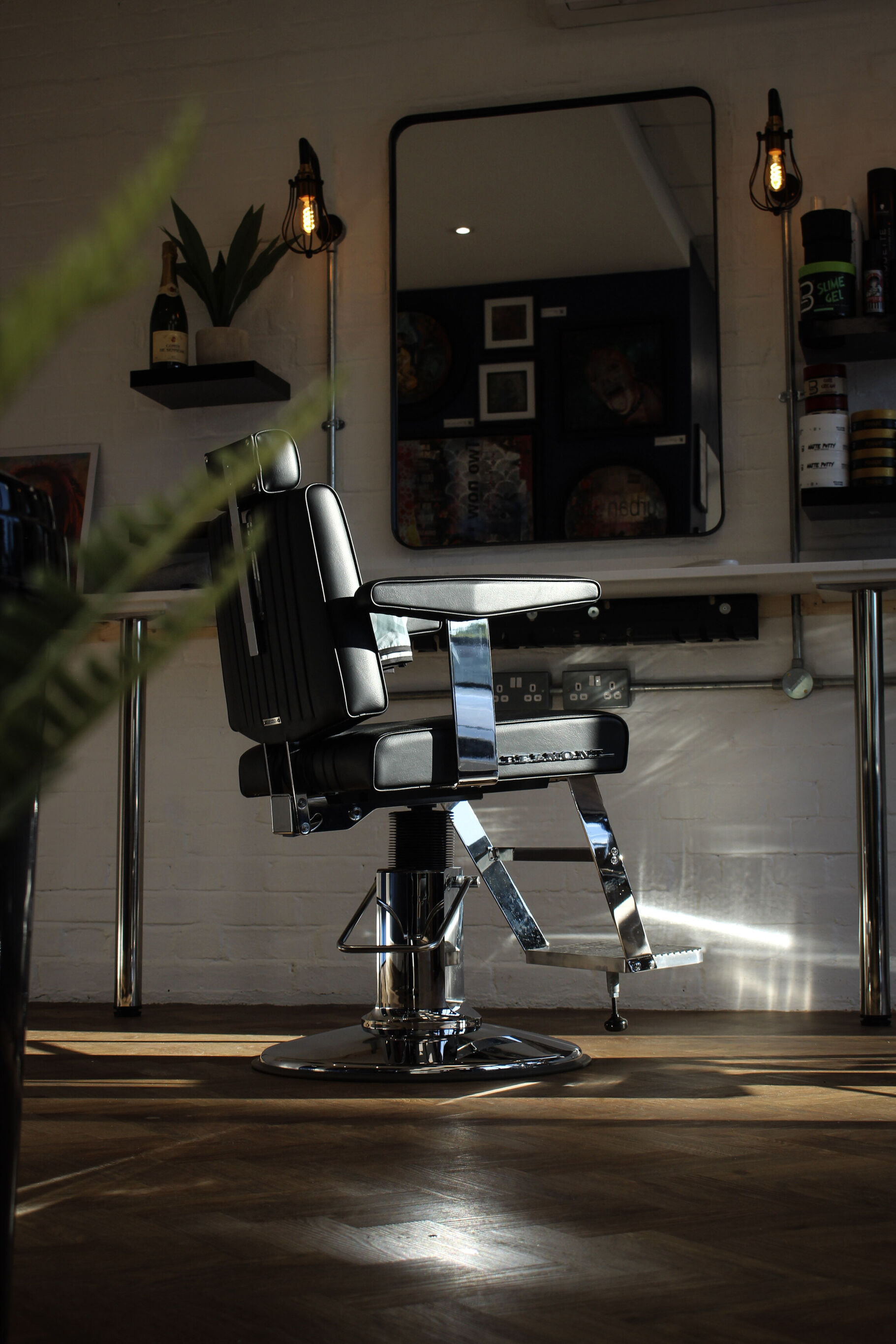 Barber chair facing the mirror under Edison lamps
