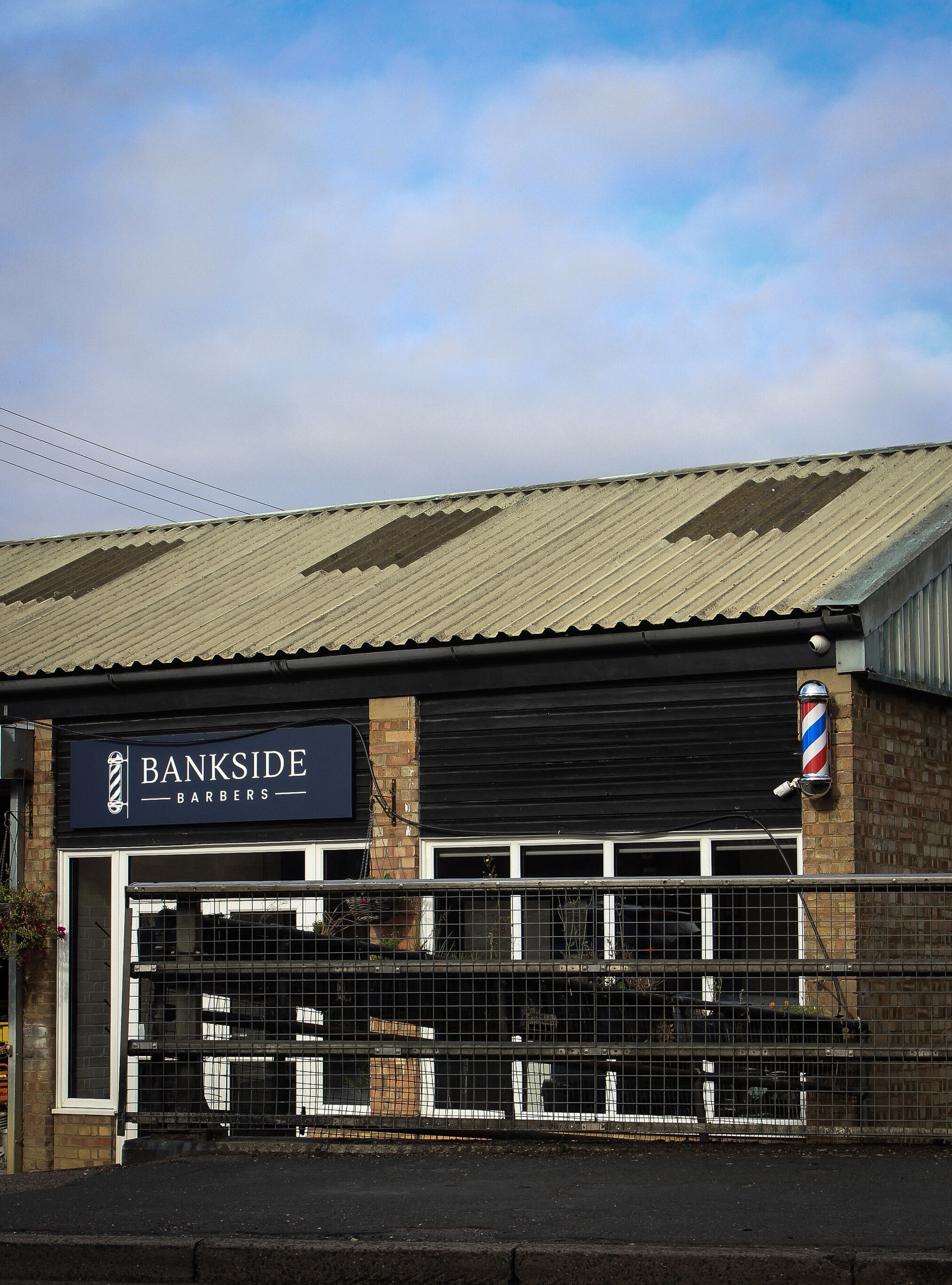 The shop building with its navy sign under a blue sky